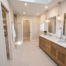 Spacious renovated bathroom with a long double vanity, bright lighting, and a large skylight.