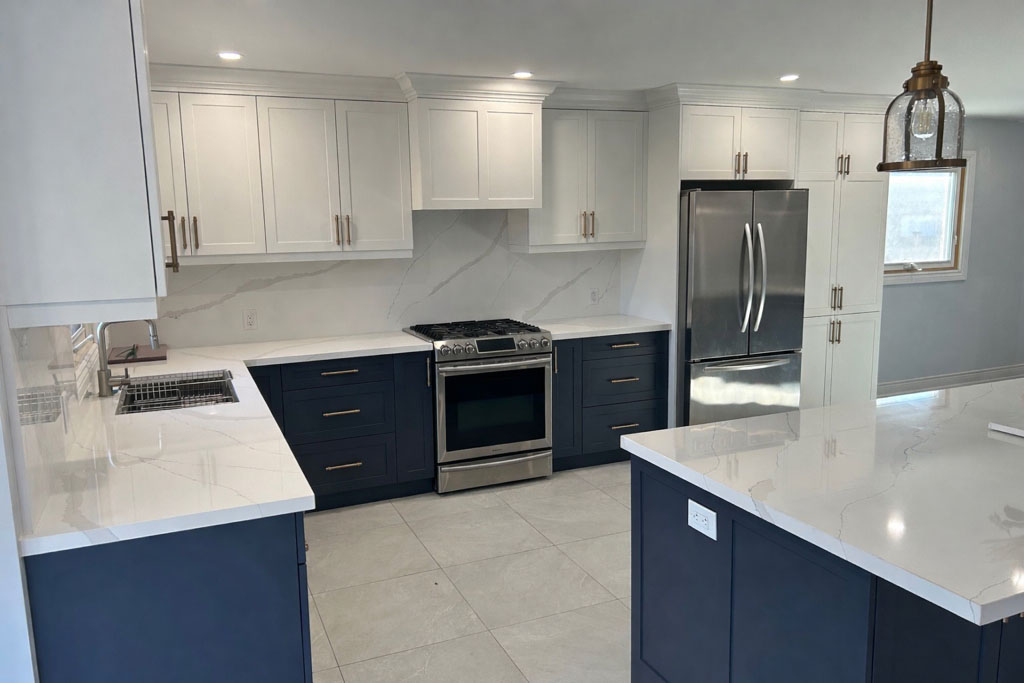 Bright two-tone kitchen with white upper cabinets, navy lower cabinets, and white quartz countertops.